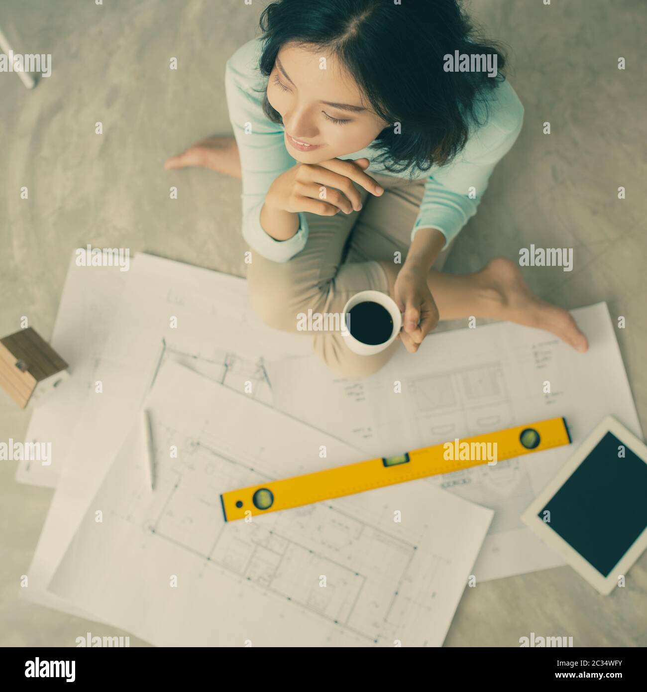 Female architect working at home.She looking blueprints Stock Photo - Alamy