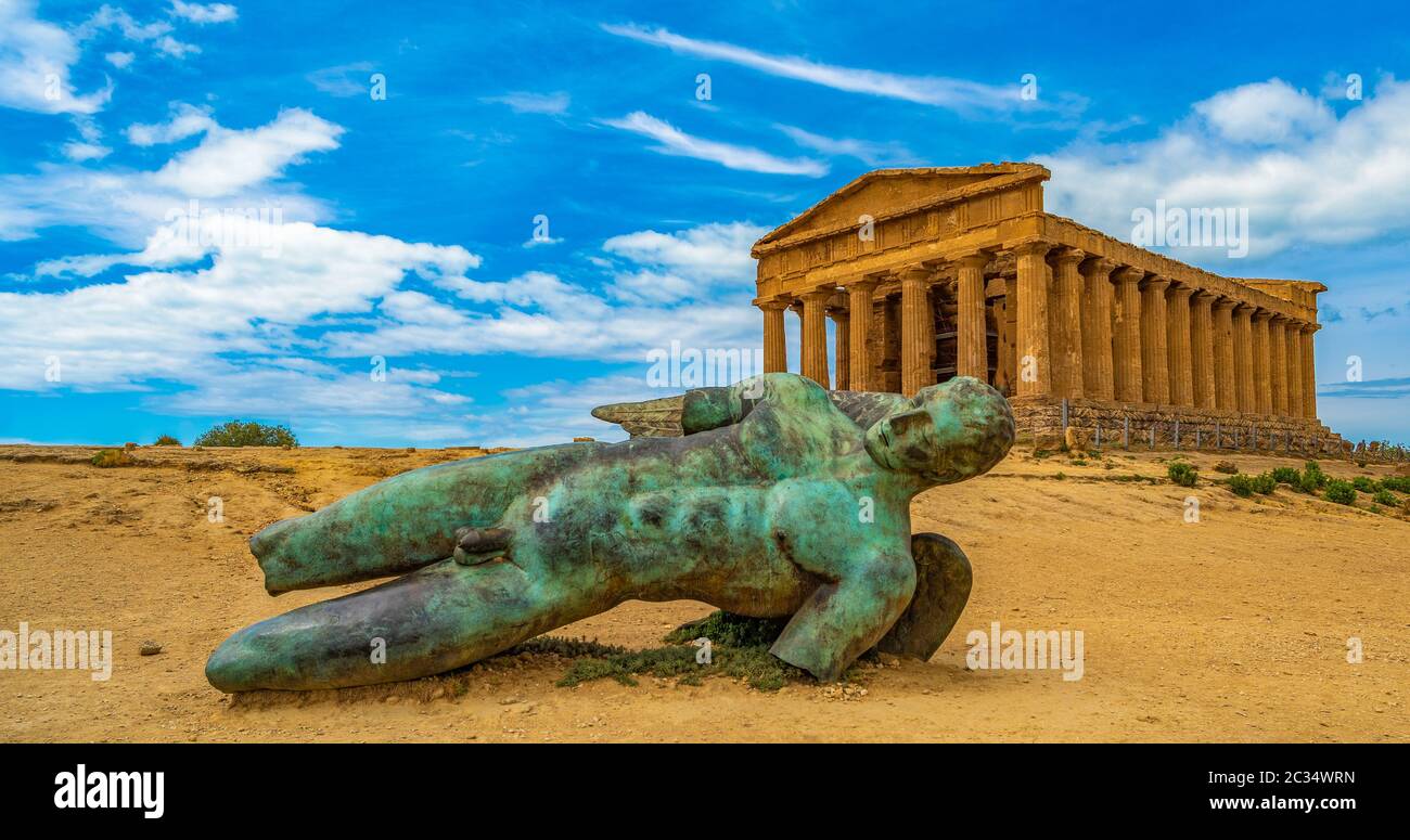 Temple of Concordia and the statue of Fallen Icarus, in the Valley of the Temples, Agrigento, Sicily, Italy Stock Photo