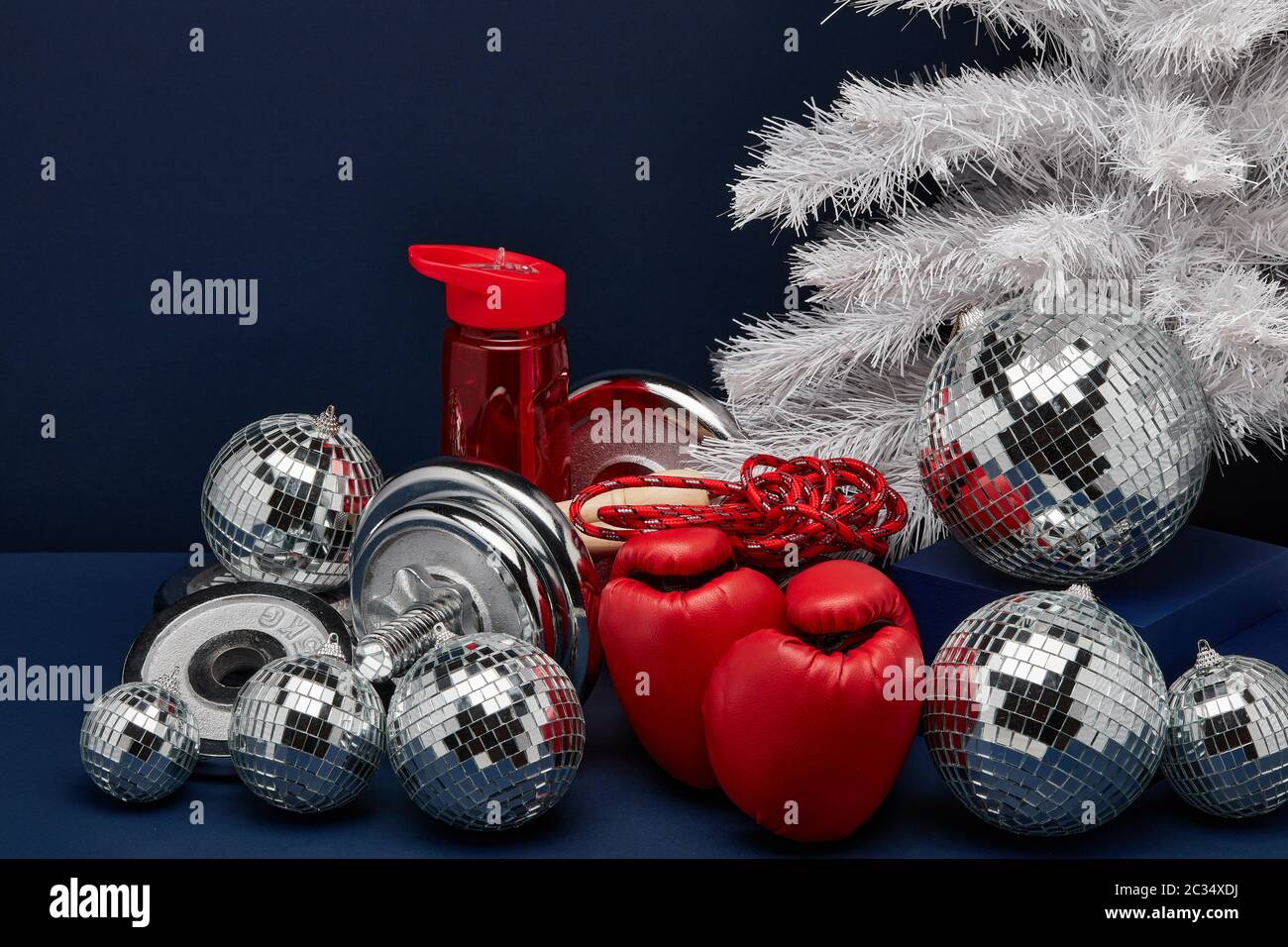 Dumbbell, boxing gloves, skipping rope, Christmas decoration on dark