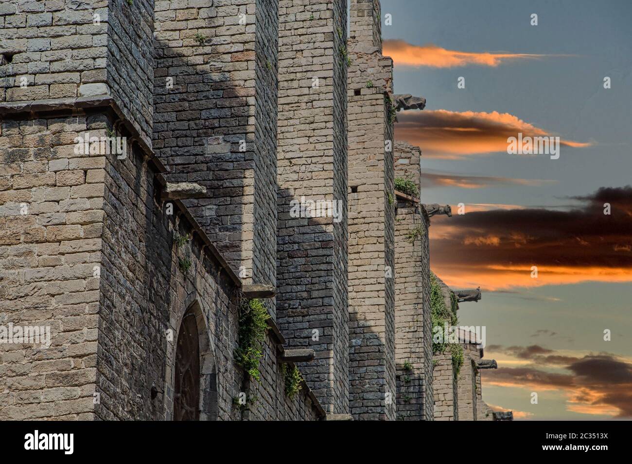 Ancient stone walls and arched windows of a medieval church in Spain ...