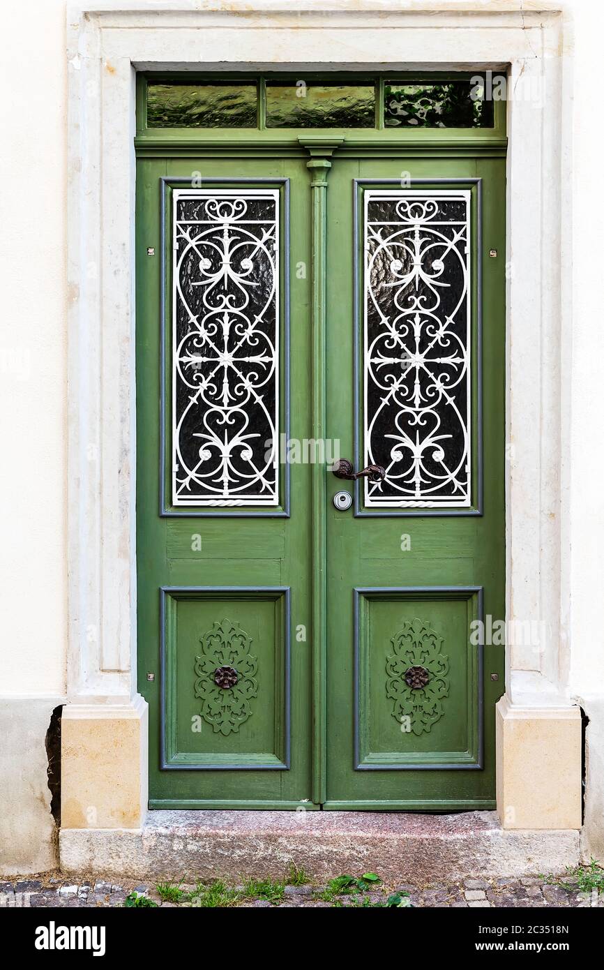 Green double-leaf front door in Art Nouveau design with a stone door frame. Stock Photo