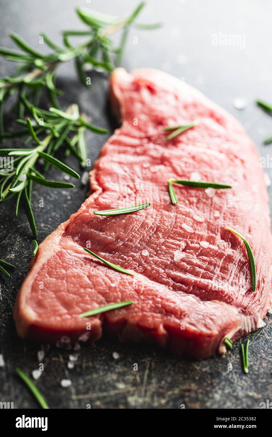 Raw veal schnitzel. Raw meat and rosemary on old kitchen table Stock Photo Alamy