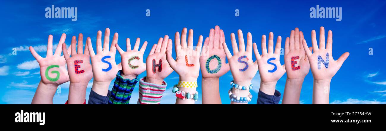 Children Hands Building Colorful German Word Geschlossen Means Closed. Blue Sky As Background Stock Photo