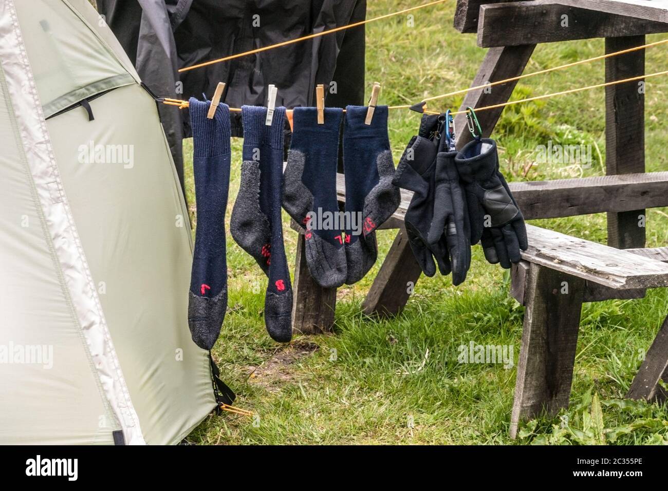 Trekking gloves and socks for drying beside the te Stock Photo