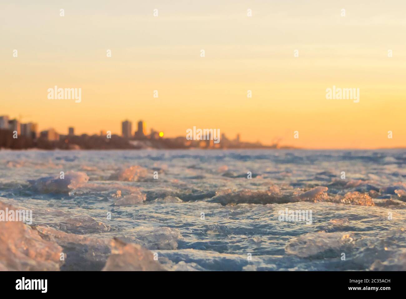 View of city in early spring in the sunset with ice pack in foreground and the city in background Stock Photo
