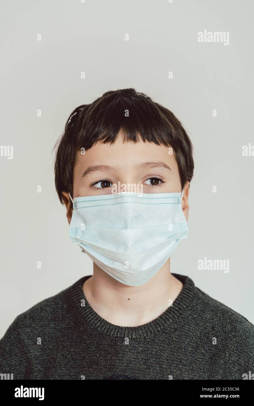 Young boy wearing face mask during Covid-19 crisis staying at home Stock Photo