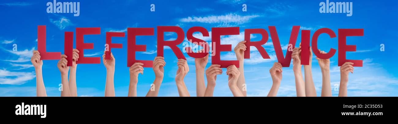 People Hands Holding Colorful German Word Lieferservice Means Delivery Service. Blue Sky As Background Stock Photo