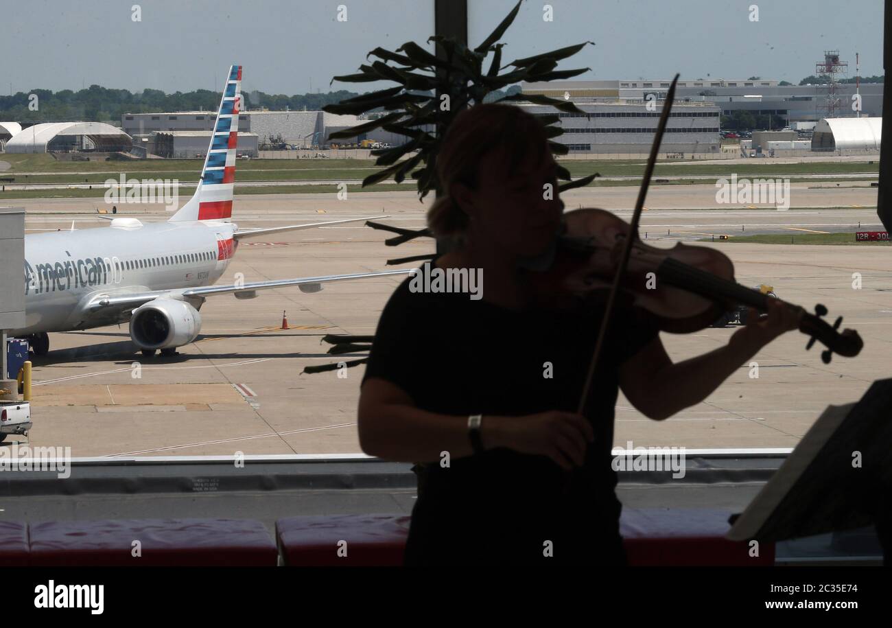 St. Louis, United States. 18th June, 2020. A violin player entertains the guests inside of the St. Louis-Lambert International Airport on its 100th birthday in St. Louis on Thursday, June 18, 2020. The oldest municipal airport in the country, was created on June 18, 1920, by Major Albert Bond Lambert and bought by the City of St. Louis eight years later. In 1956, Minoru Yamasaki's iconic arched terminal opened, becoming the forerunner of many modern airline terminals. Photo by Bill Greenblatt/UPI Credit: UPI/Alamy Live News Stock Photo