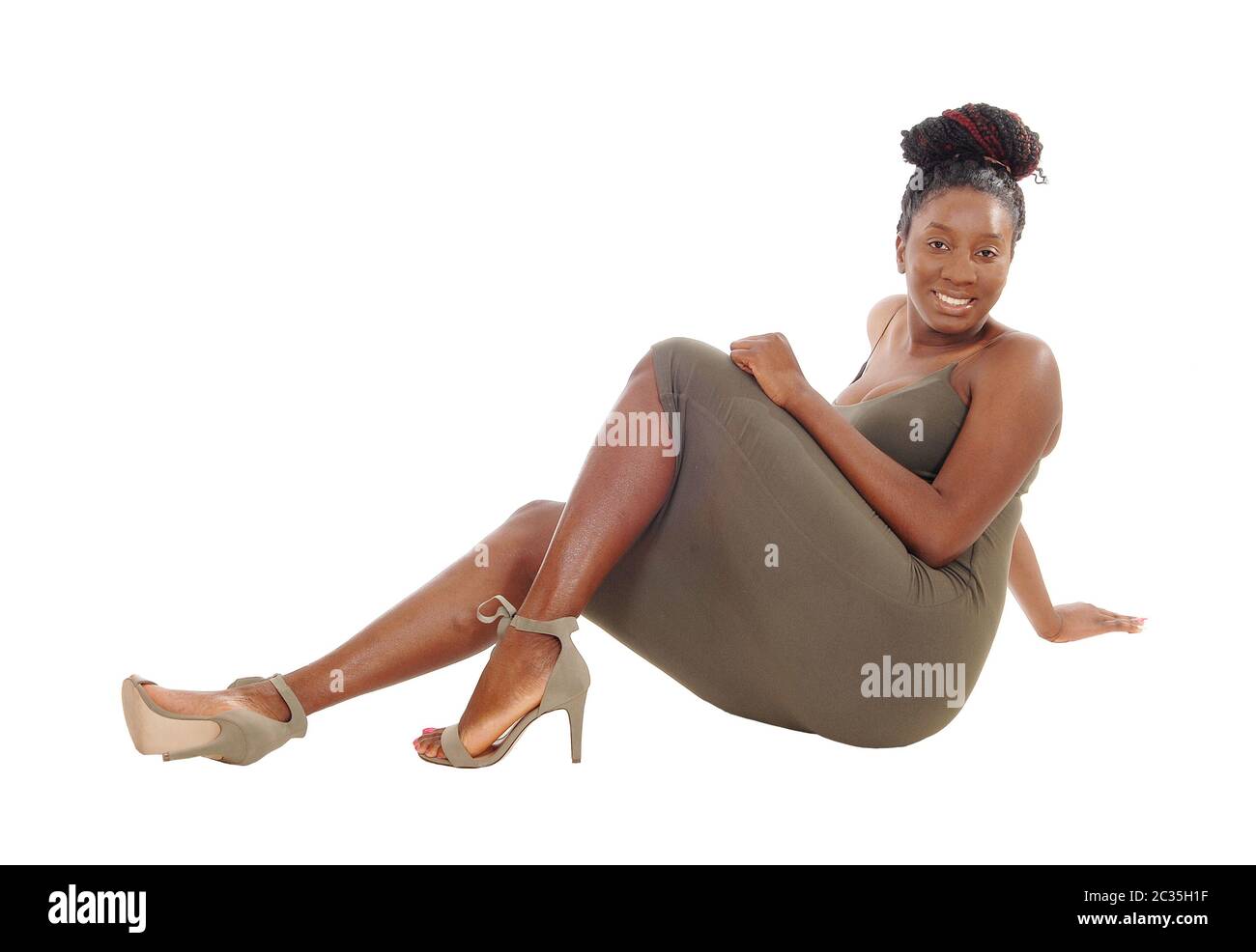 A beautiful African American woman in a dress sitting on the floor ...