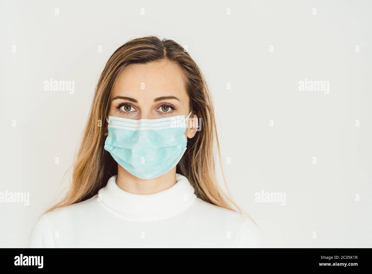 Woman with corona mask protecting her from Covid-19 staying at home in quarantine Stock Photo
