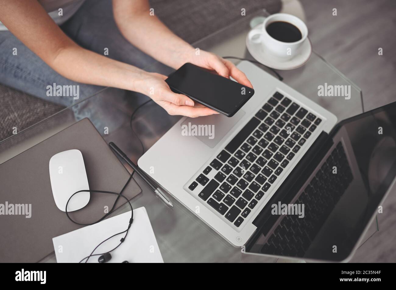 Female hands using smart phone in interior workplace, freelance business woman using cell phone at office desk, working from home using smart phone Stock Photo
