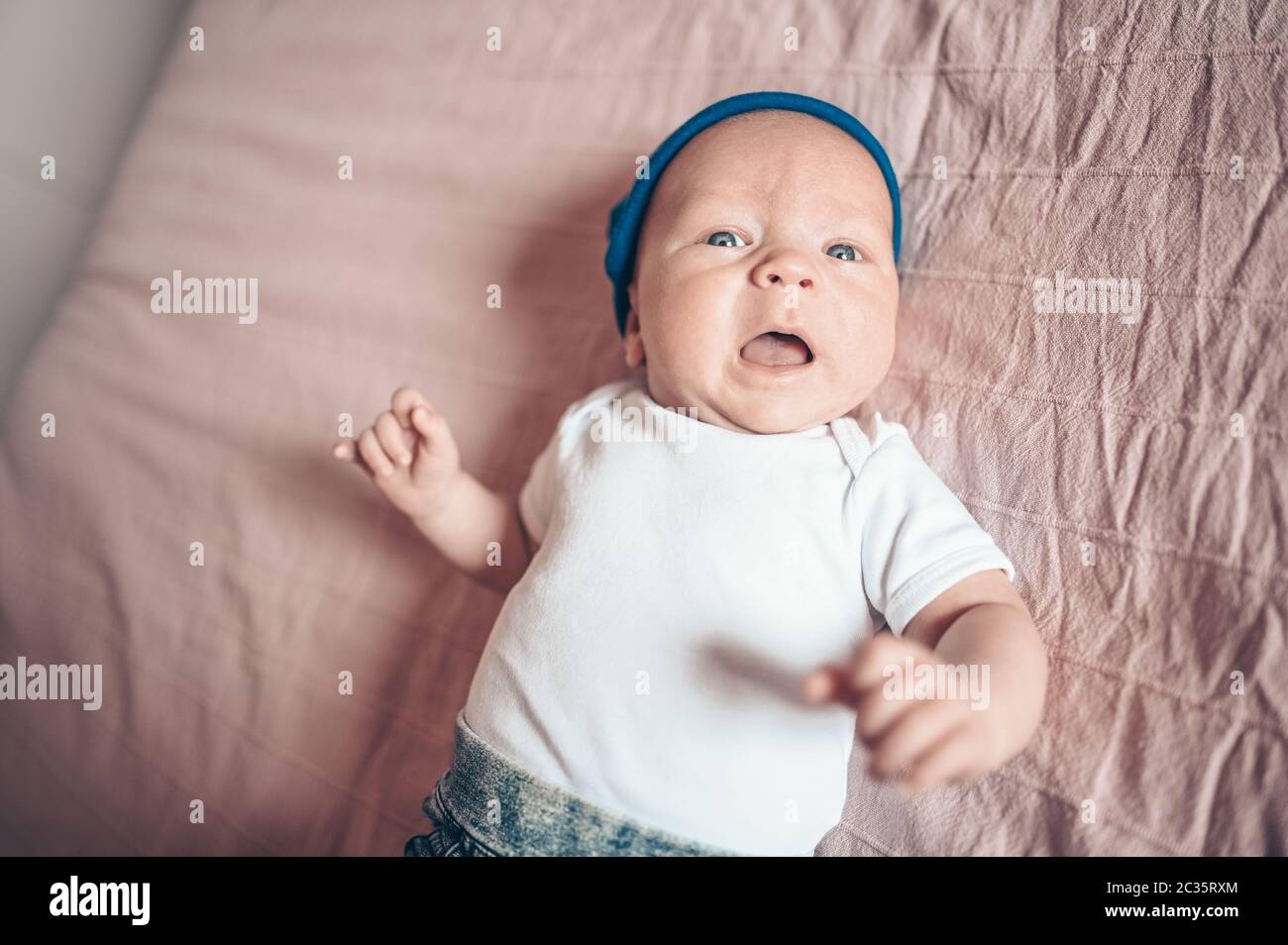 Cute little baby boy lying on pink blanket at bedroom. Newborn. Baby
