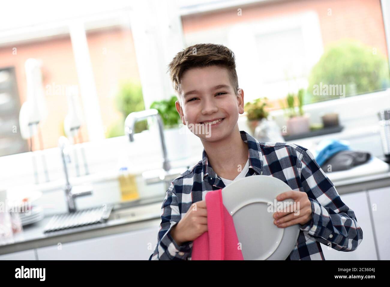 Junge trocknet Teller ab Stock Photo