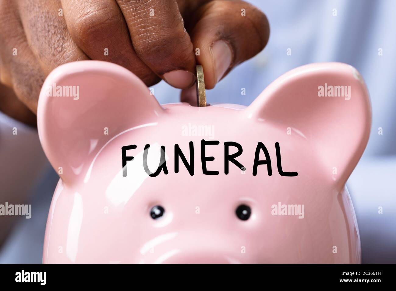 Person Saving Money For Funeral By Inserting Coin In Piggy Bank With