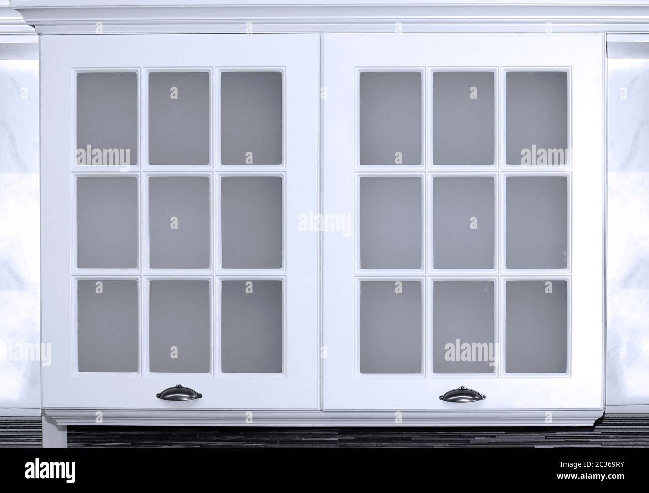 Image showcasing Closed wooden and glass doors kitchen cabinets Stock Photo - Alamy