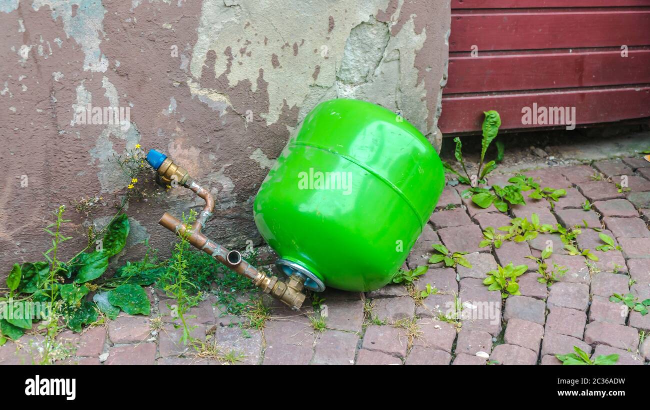 Green Propane bottle lying improper on the street Stock Photo