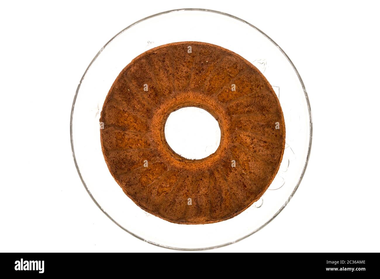 Circular marbled cake laying on a glass tray top view on a white