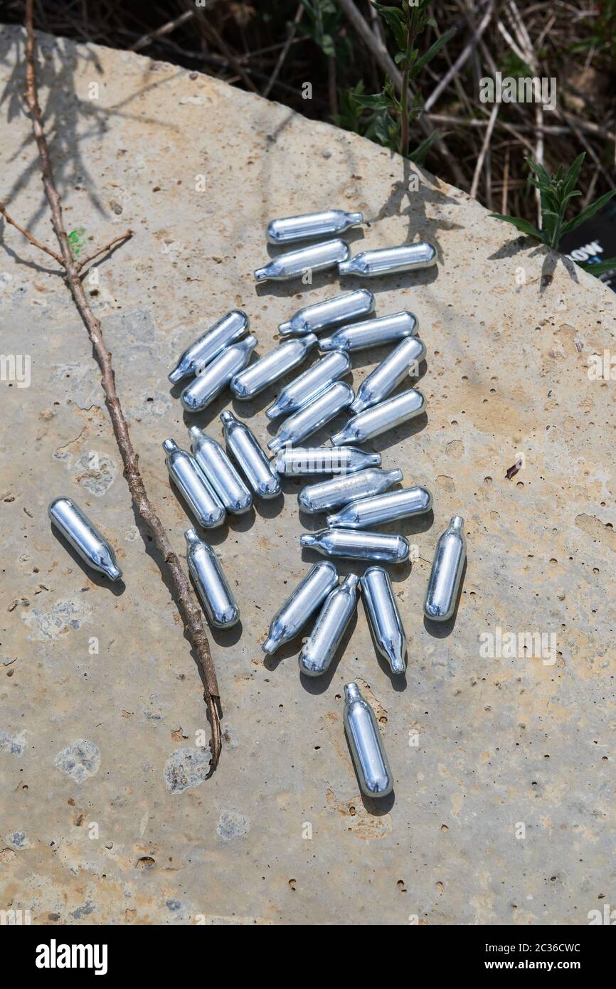 Empty pressurised metal canisters of nitrous oxide (laughing gas