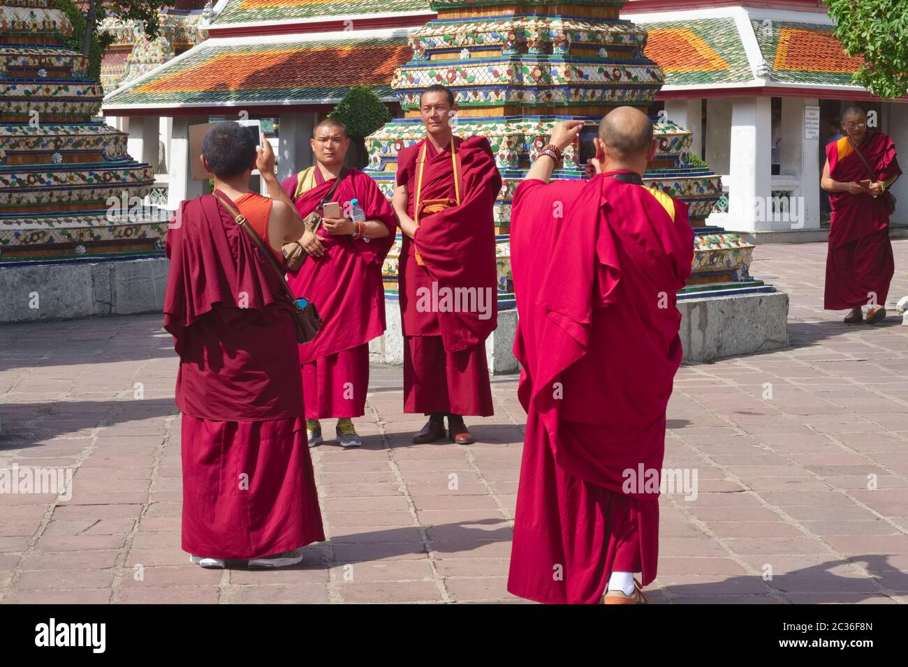 Tibetan monks at Wat Po (Wat Phra Chetuphon), the 'Temple of the Reclining Buddha', Bangkok, Thailand, taking souvenir photos Stock Photo