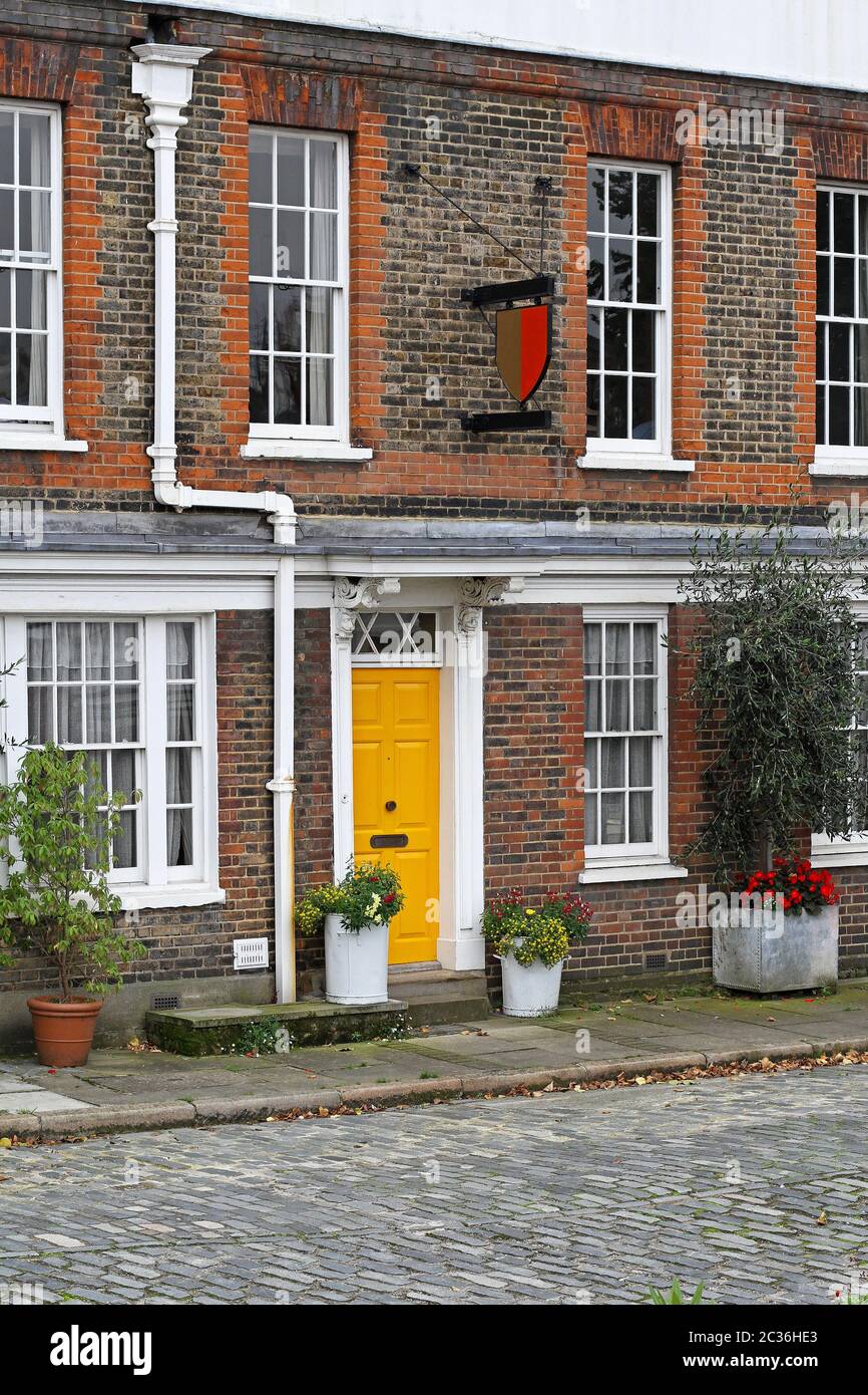 Old english house with brick wall and yellow door hi-res stock ...