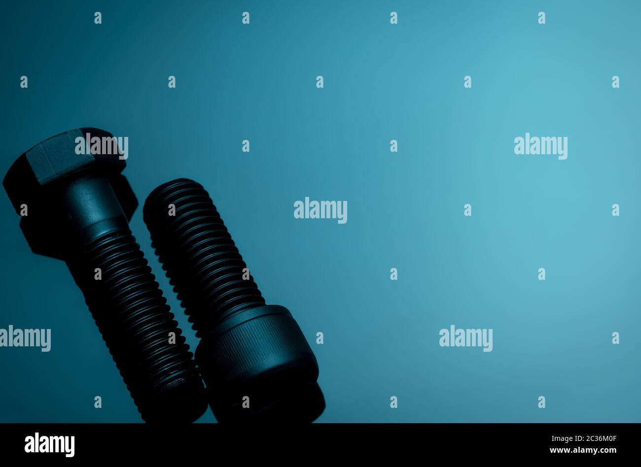Metal bolts on blue background. Hardware tools. Closeup hex head bolt