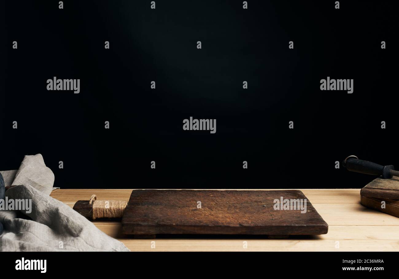 very old empty wooden rectangular cutting board, black background Stock Photo