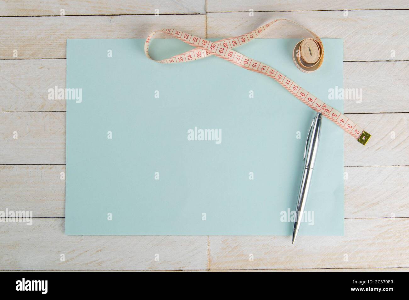 https://c8.alamy.com/comp/2C370ER/blank-open-blue-paper-with-centimeter-tape-on-white-wooden-table-with-space-for-text-or-business-food-concept-concept-sport-diet-fitness-healthy-e-2C370ER.jpg