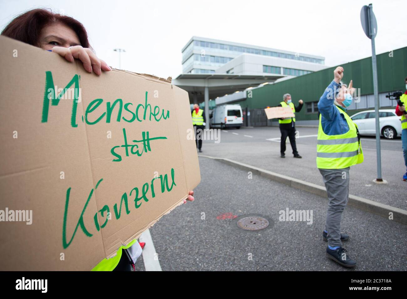 Stuttgart, Germany. 19th June, 2020. A demonstrator is holding a sign in front of the Stuttgart airport saying 'People not corporations'. The services union Verdi is calling for protest events at many German airports and airline locations. Among other things, it is about the conclusion of a collective agreement to increase short-time work due to the Corona pandemic between Verdi and the employers' association of ground handling service providers ABL. Credit: Tom Weller/dpa/Alamy Live News Stock Photo