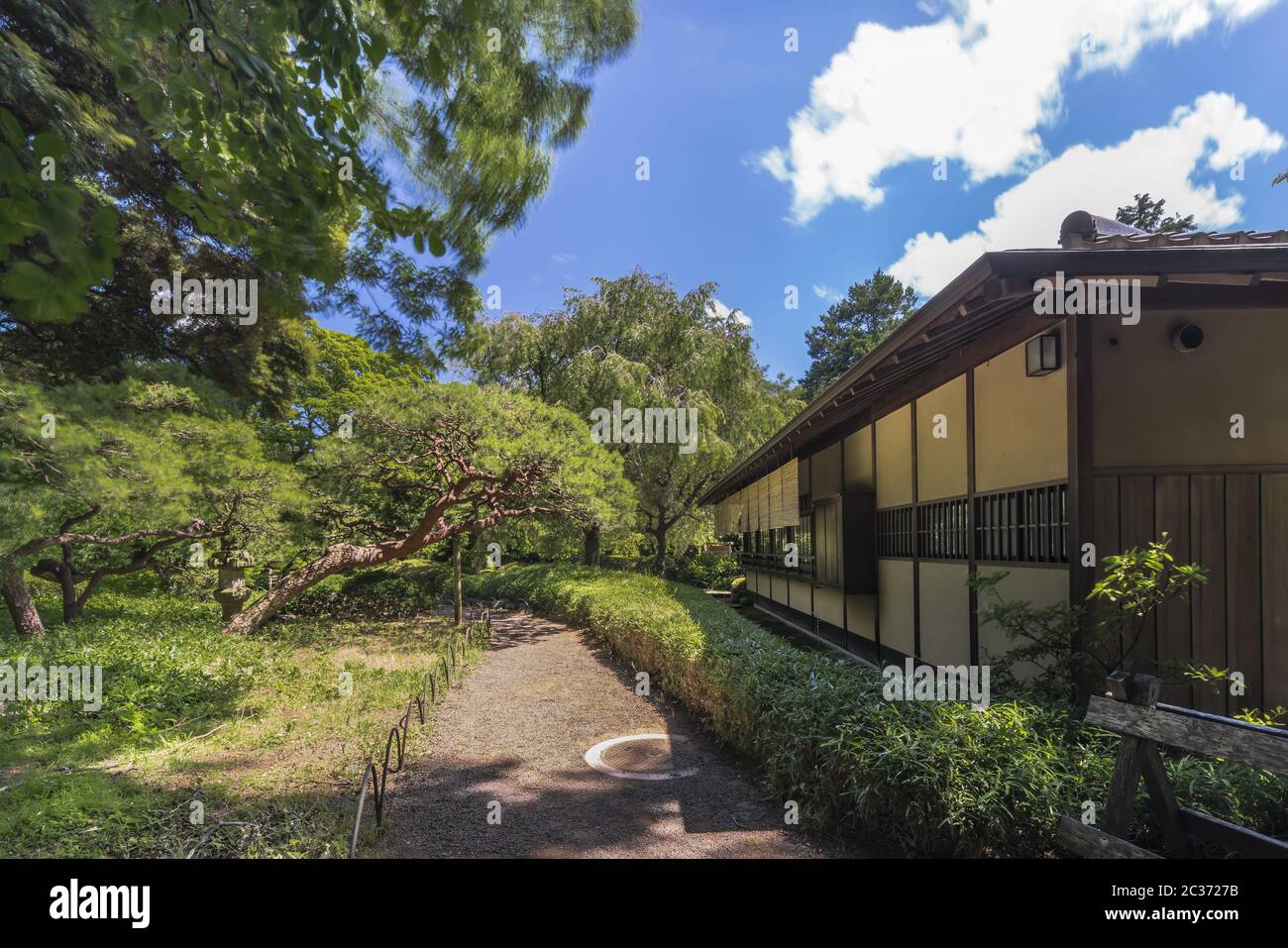 Tea House named Rakuutei lined by a path surrounded by pine trees and