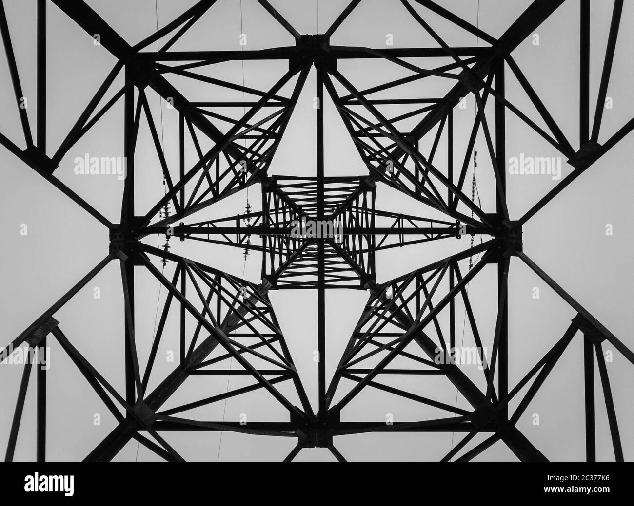 Underneath a truss pillar construction. Different geometric shapes, patterns of a steel structure. Metallic texture of an electricity pole. Stock Photo