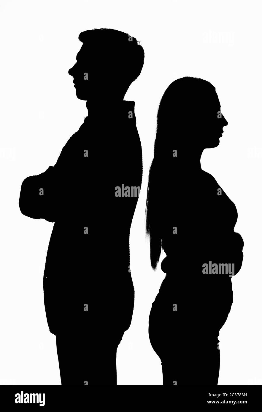 A silhouetted contoured black white portrait of a young couple standing with their backs to each other Stock Photo