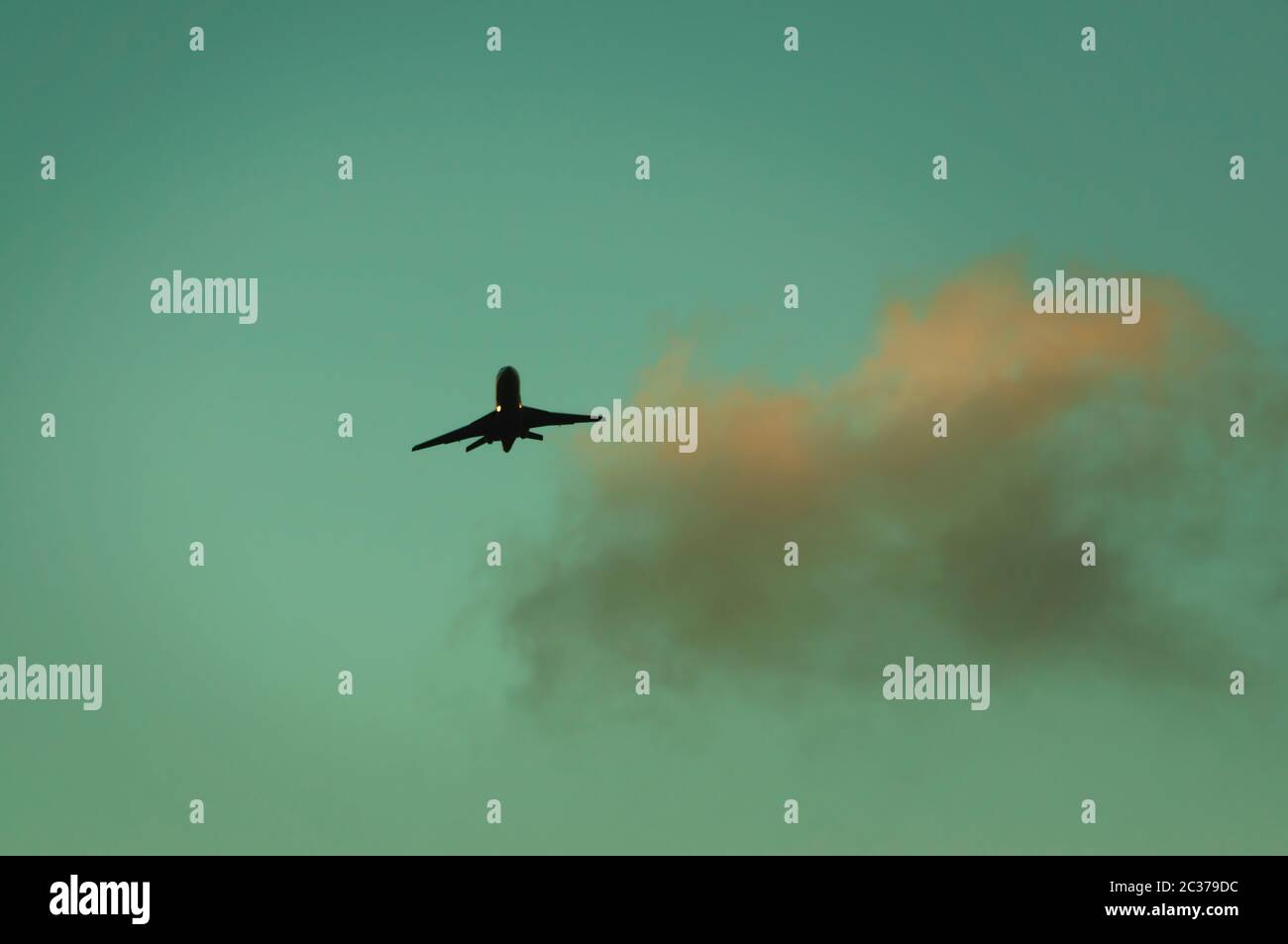 Passenger jet in sky at dusk. Stock Photo