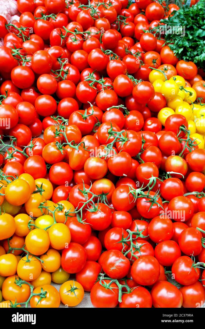 Bunch of cherry tomatoes on the market vertical Stock Photo - Alamy