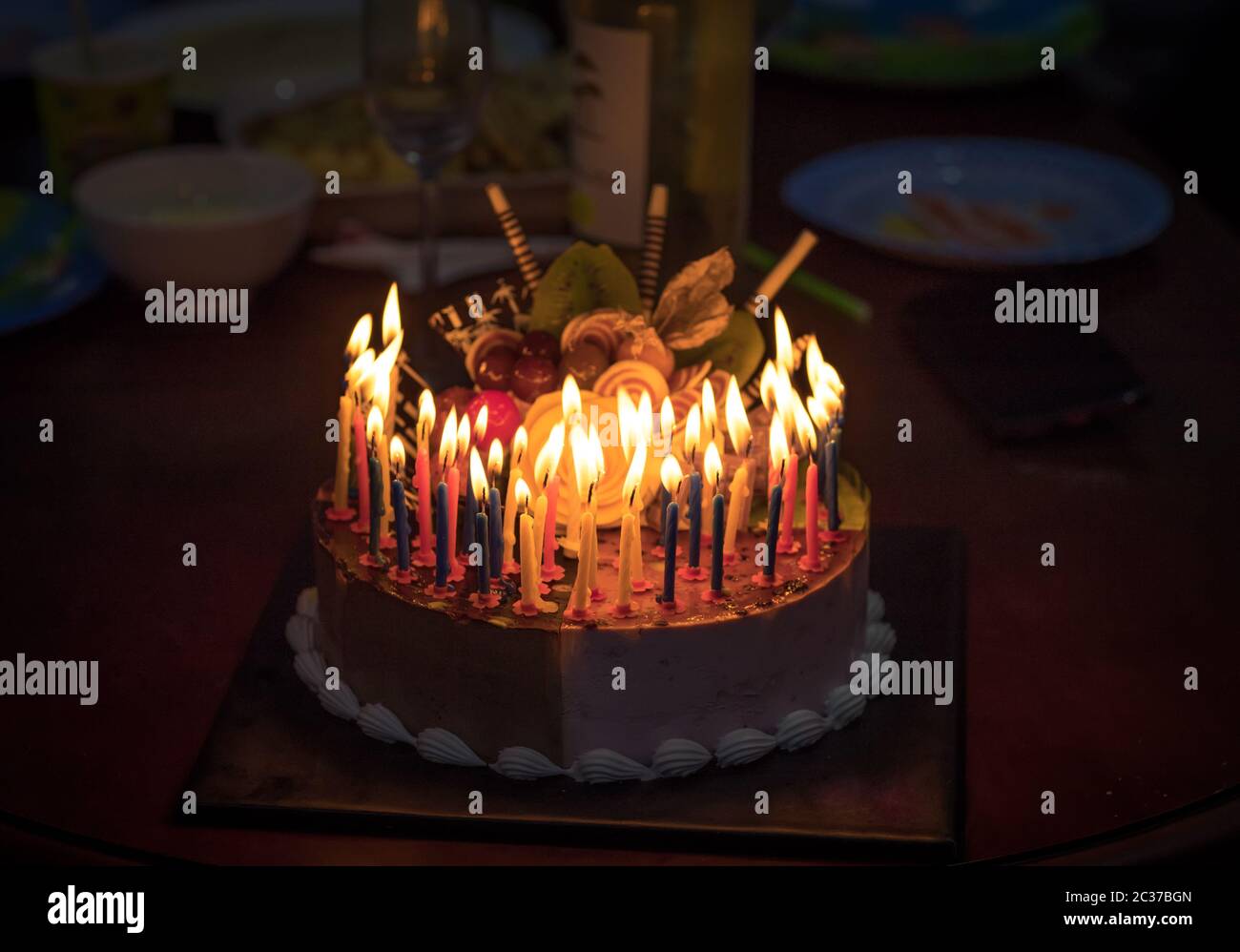 Birthday cake with candles in dark Stock Photo - Alamy