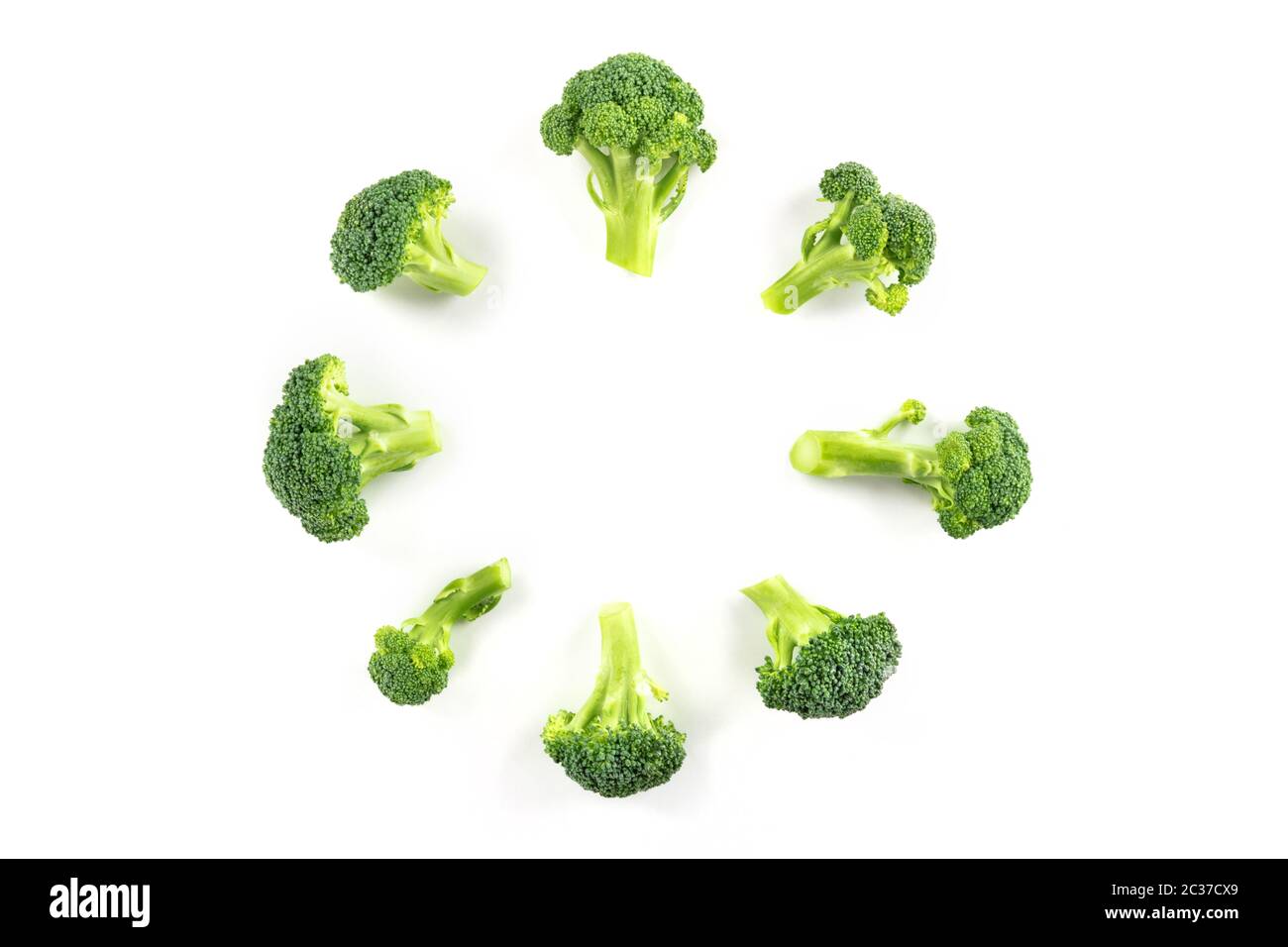 Broccoli florets, shot from the top on a white background, forming a ...