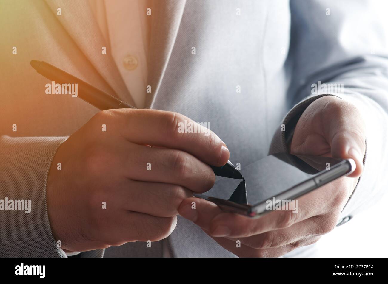 Man signing document on smartphone in business man background Stock Photo