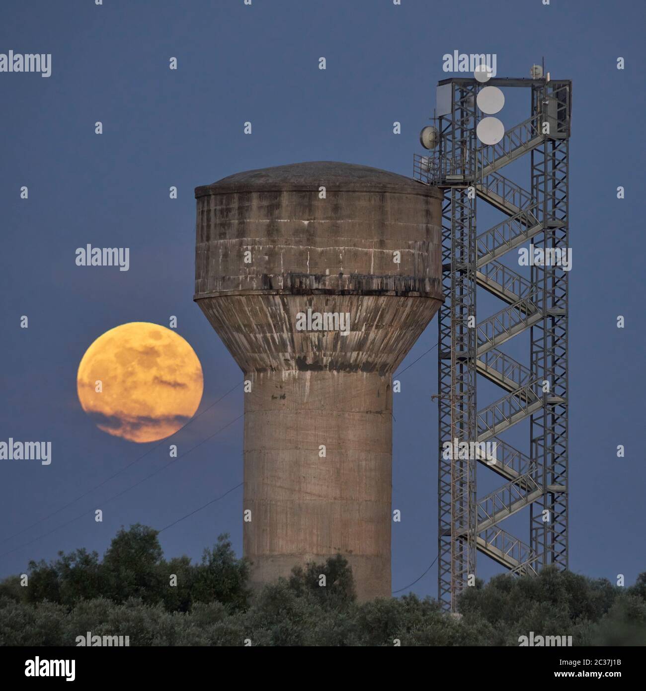 Concrete water tank and full moon of honey in Mollina, Malaga. Spain Stock Photo