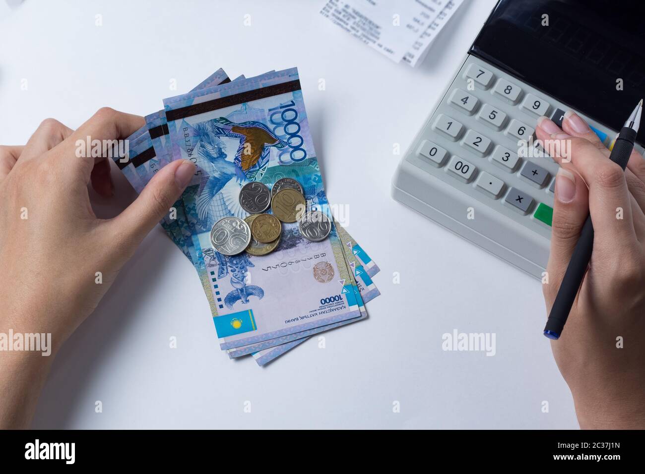 Tenge at the cashier accountant in the hands of the workplace in the office. The cashier counts the money KZT in the workplace in Kazakhstan. Salary i Stock Photo