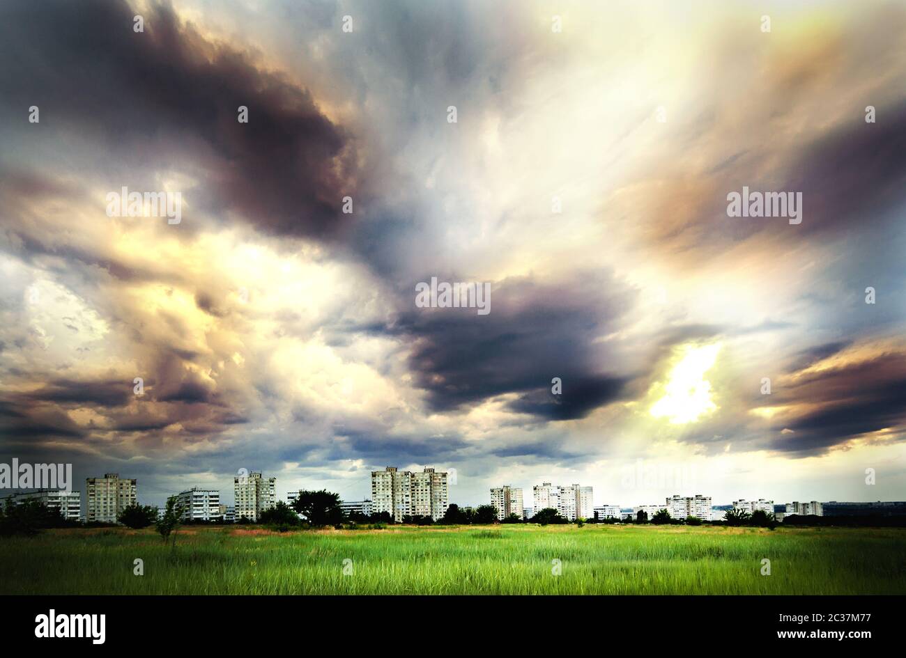 Dramatic sky over city buildings and a field Stock Photo - Alamy