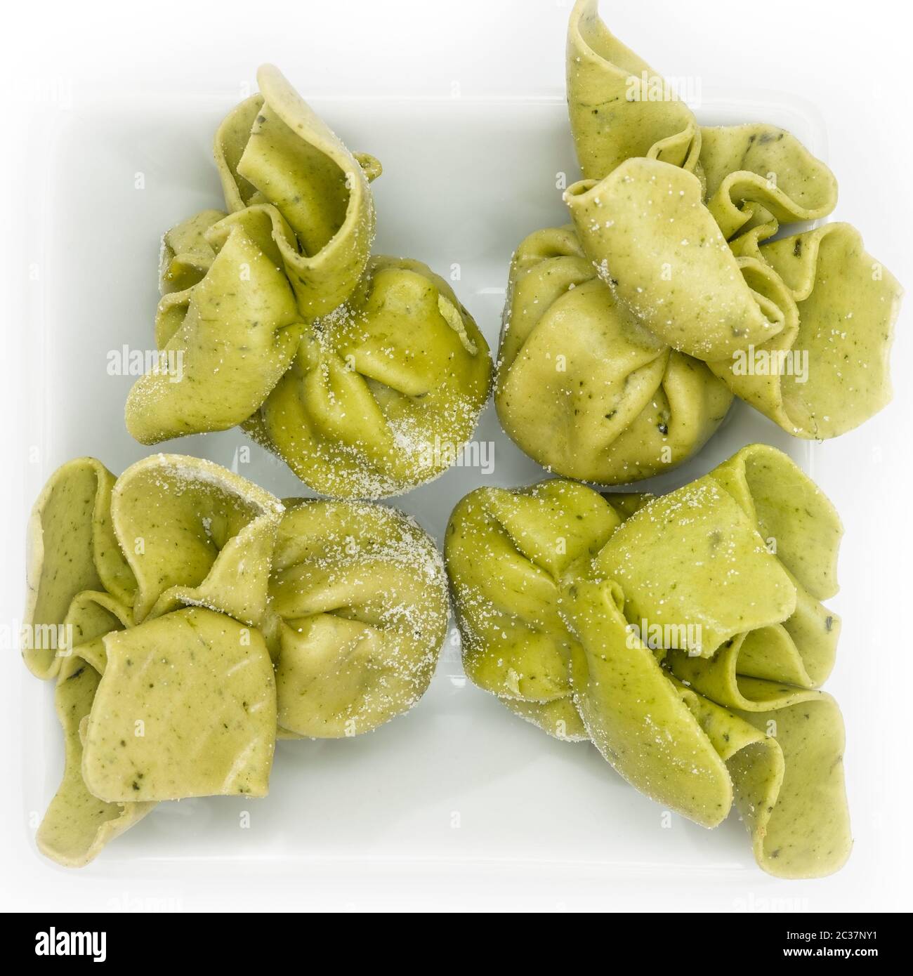 Green tortellini pasta with cheese and spinach filling in white bowl