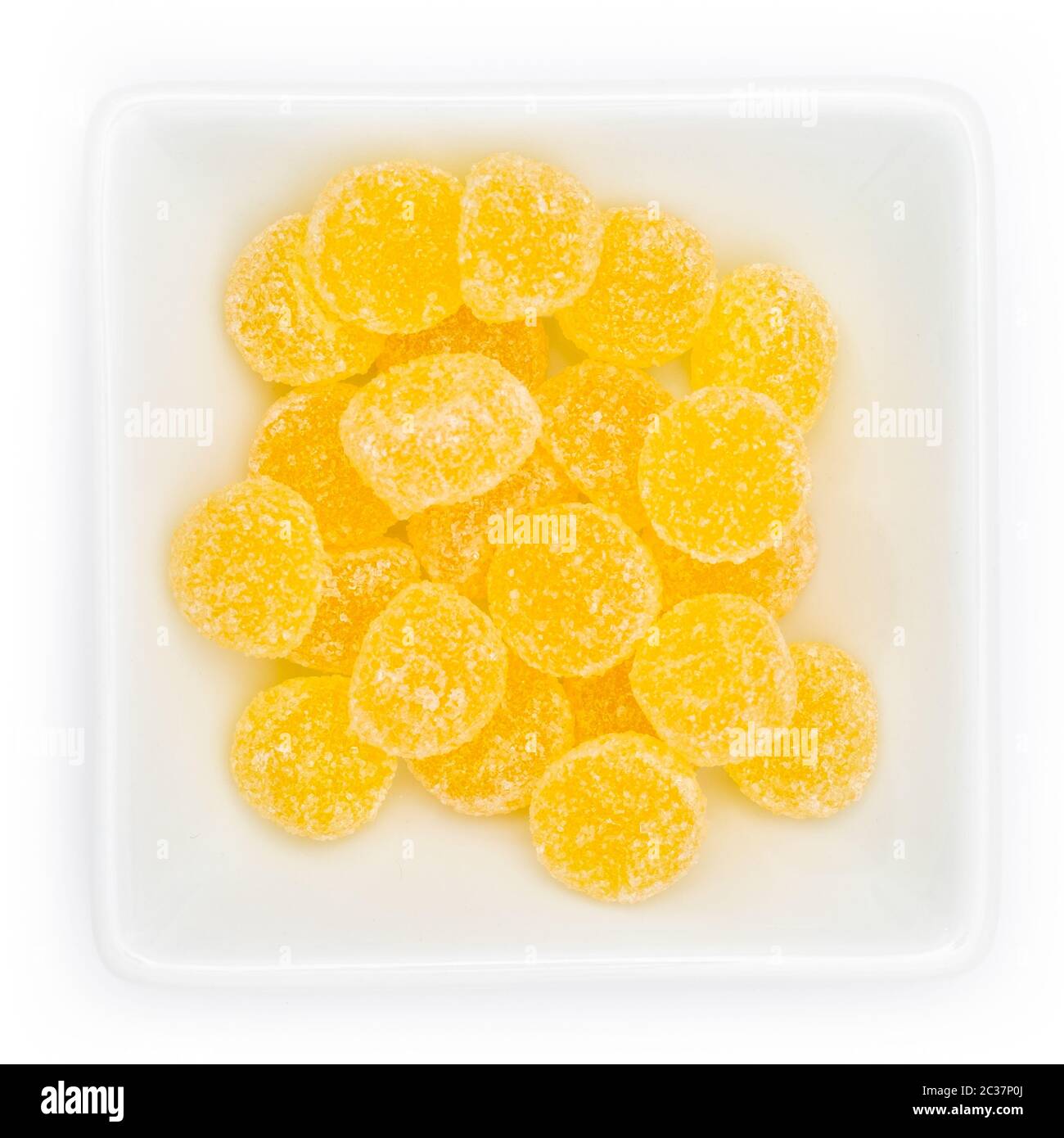 Yellow gum drops in a white bowl in top view Stock Photo