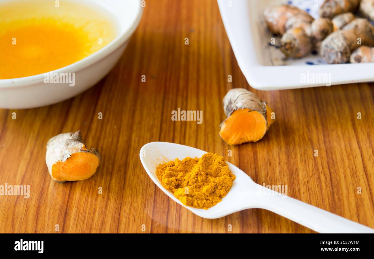 A table spoon of Pure Turmeric Haldi Powder spices. Turmeric with milk Indian cuisine recipe everyday can prevent digestion, stomach ulcers, diarrhoea Stock Photo