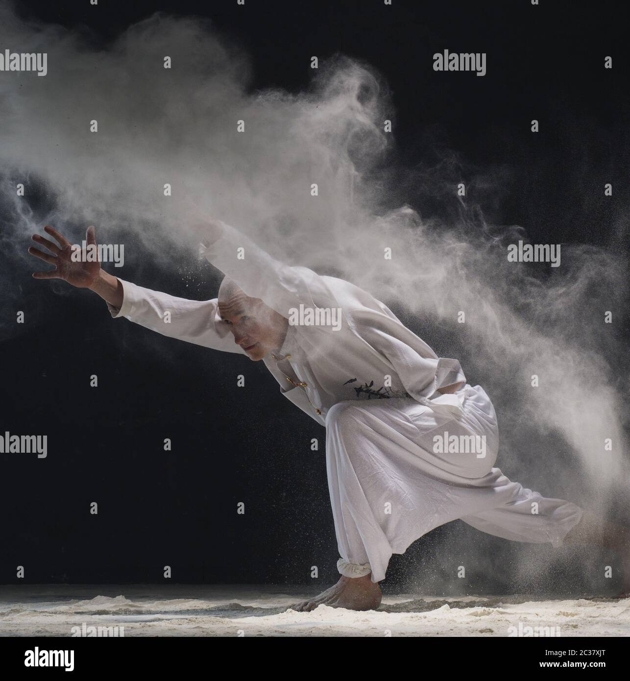 Male doing yoga in white dust cloud - concept of power Stock Photo