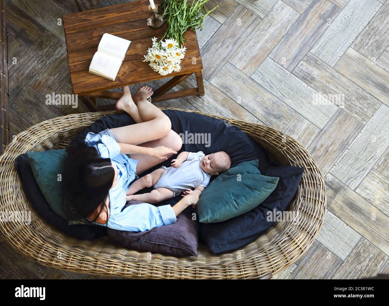 Mother with baby resting on sofa Stock Photo