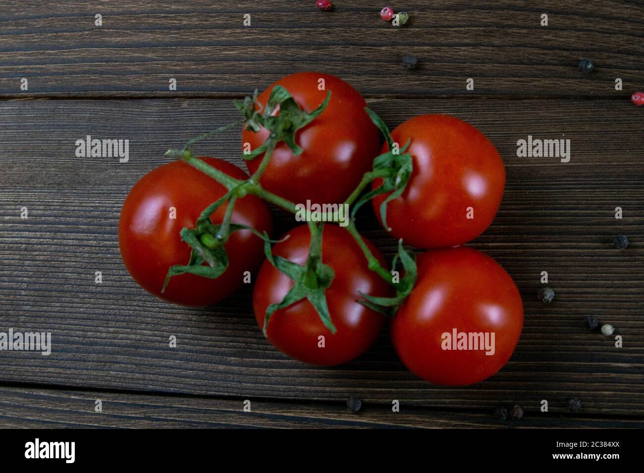 Branch of ripe red cherry tomatoes on dark wooden board food ...