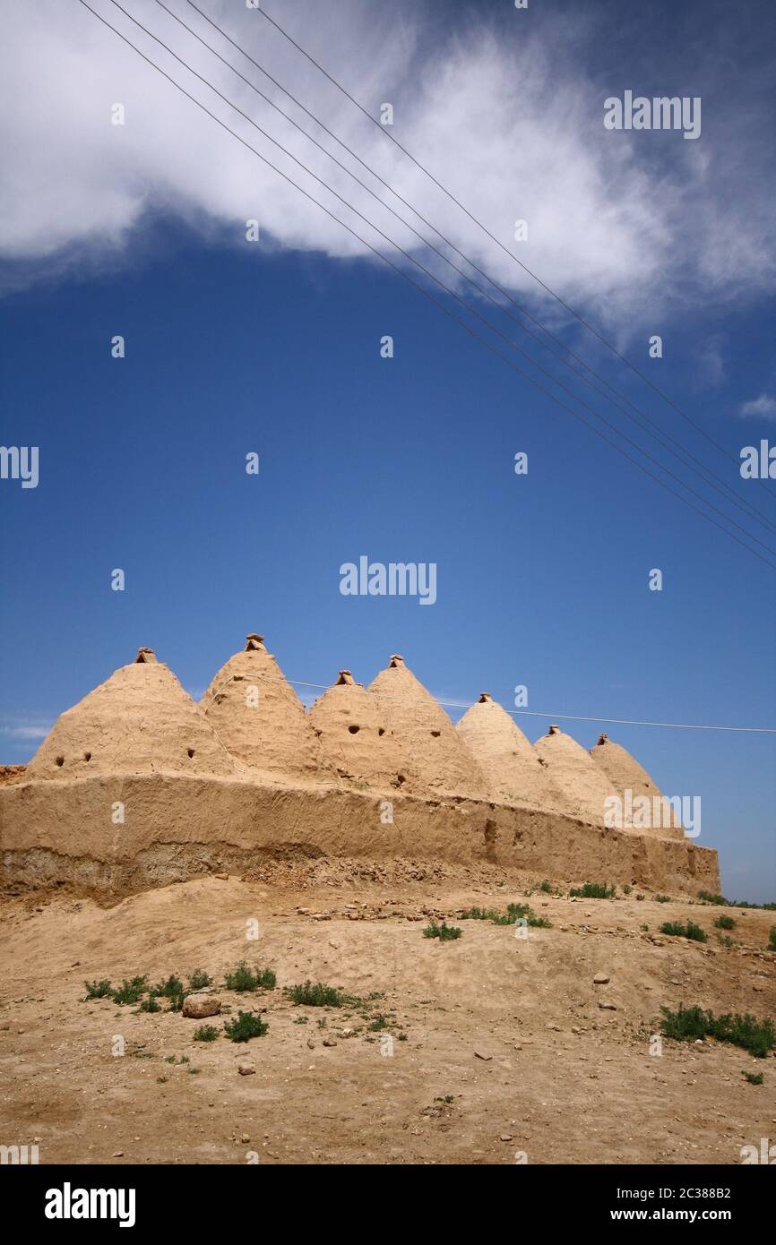 Traditional beehive mud brick desert houses,Harran, Turkey. Mud brick buildings topped with domed roofs and constructed from mud and salvaged brick. Stock Photo