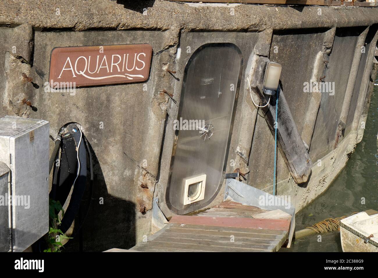 Unusual door with catflap on the houseboat 'Aquarius'.  Riverbank, River Adur, Shoreham-by-Sea, Brighton, UK. Stock Photo