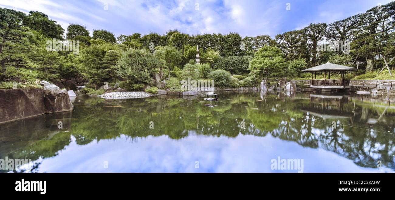 Hexagonal Gazebo Ukimido in the central pond of Mejiro Garden where ducks are resting and which is s Stock Photo