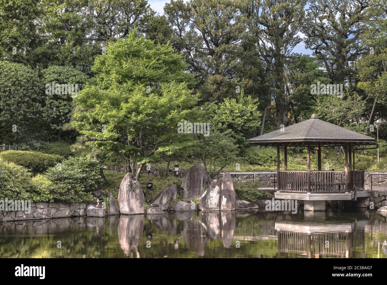 Hexagonal Gazebo Ukimido in the central pond of Mejiro Garden where carp swim and which is surrounde Stock Photo