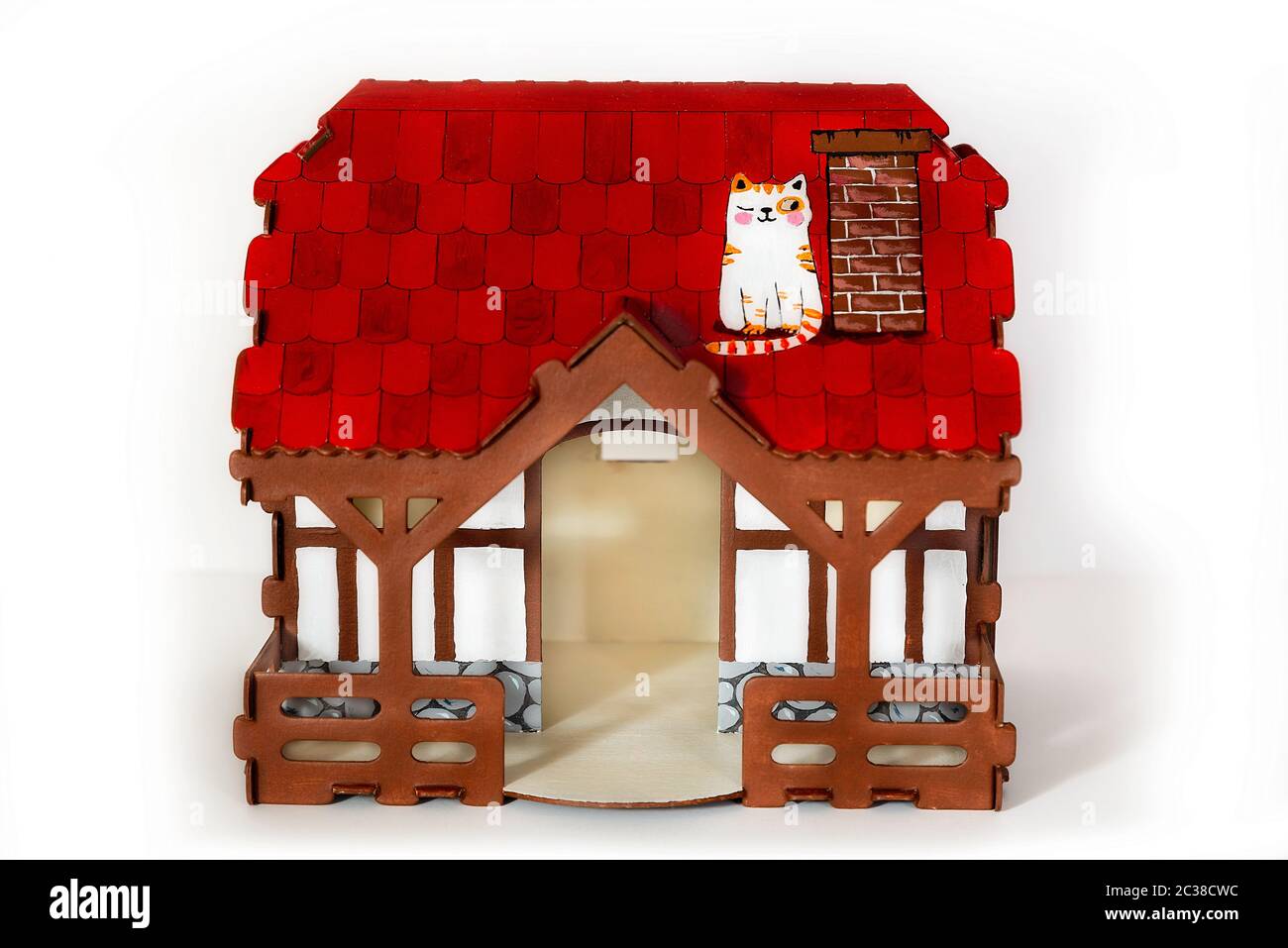 Toy house made of rural cardboard, front view, with a red roof on a